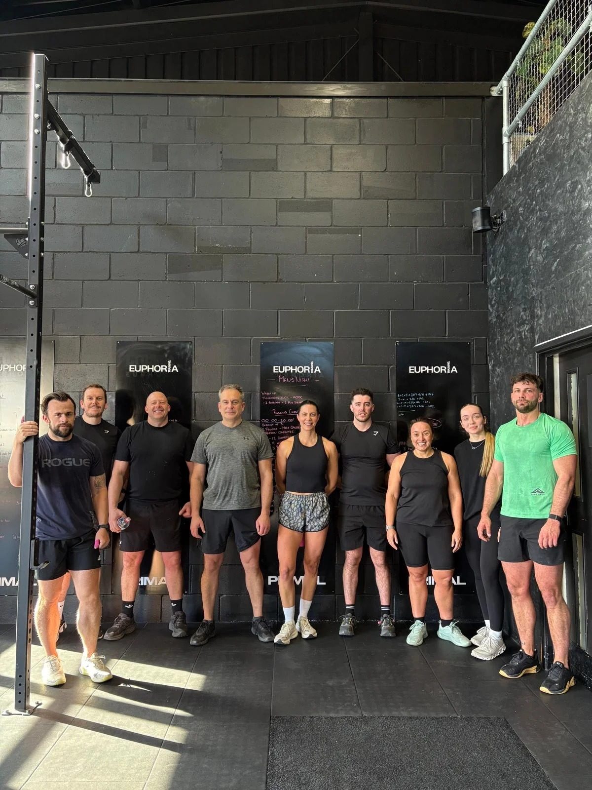 Members lined up in front of the wall